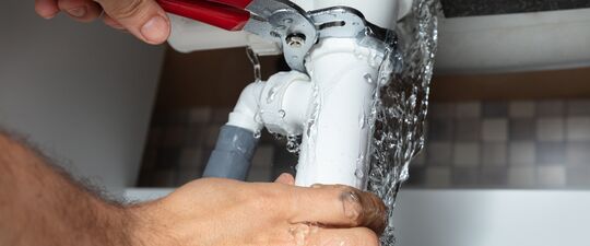 fixing a leaking interior plumbing pipe with pliers