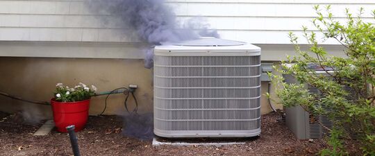 a smoking air conditioner unit outside of a home