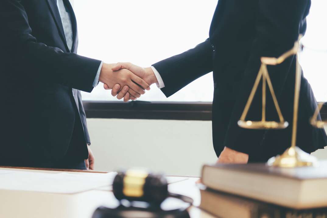 Law and Legal services concept. Lawyer and attorney having team meeting at law firm. Lawyer and businessman handshake.