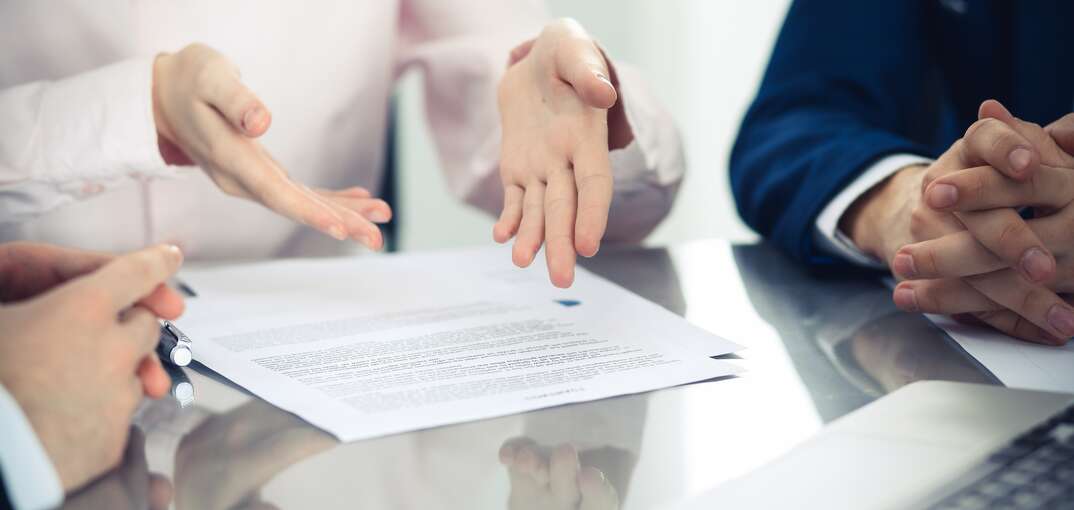 group of business people and lawyers discussing contract papers sitting at the table, close up