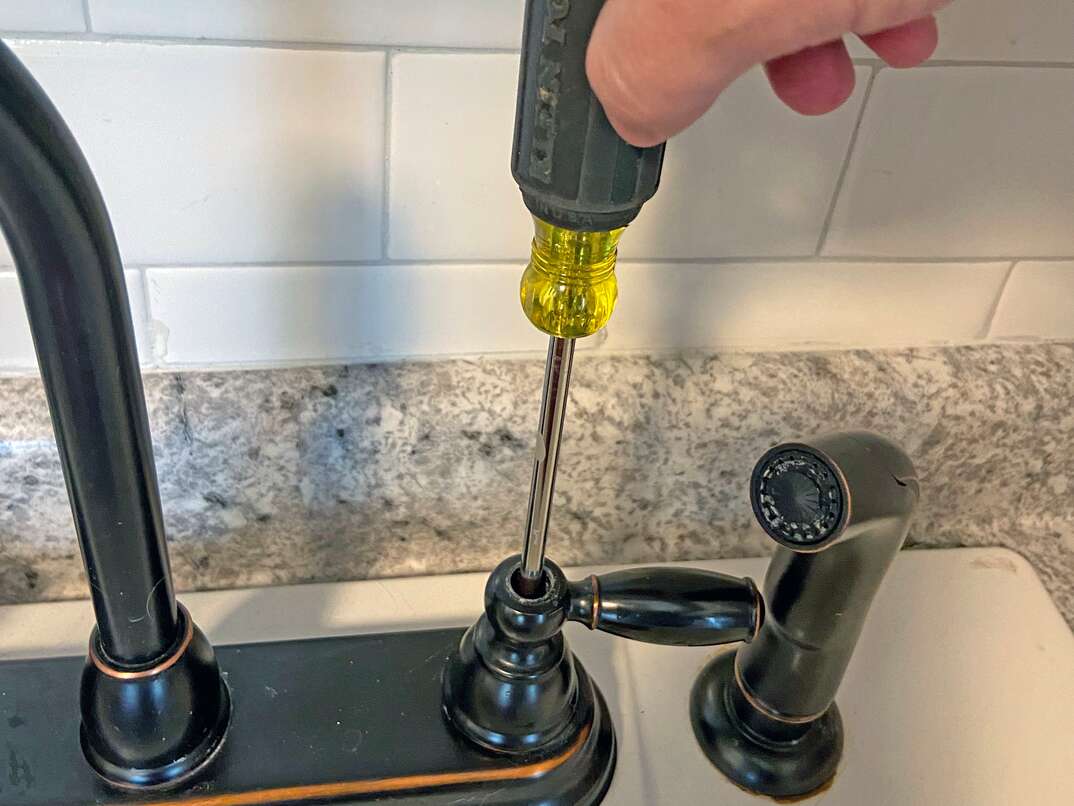 step-by-step instructional guide on how to tighten the temperature handles on a sink  In this case, we are looking at an oil rubbed faucet on a utility sink