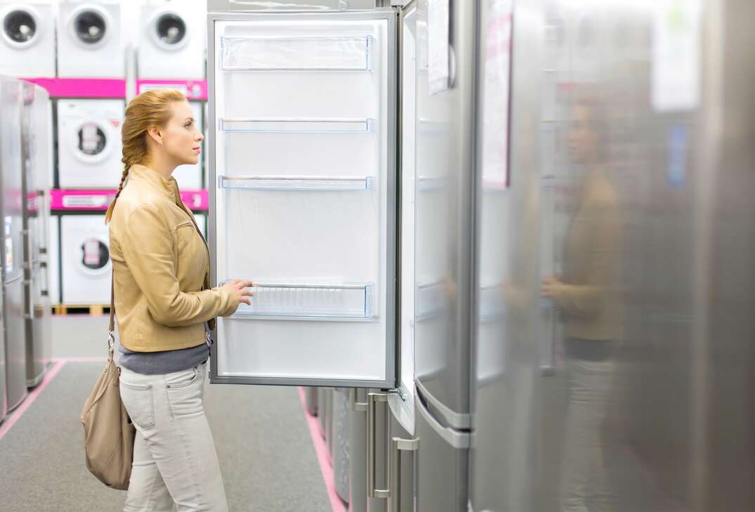 woman buys the refrigerator in shop