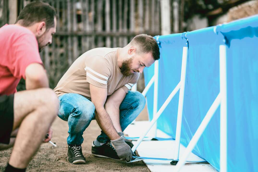 handsome male workers balancing pool legs