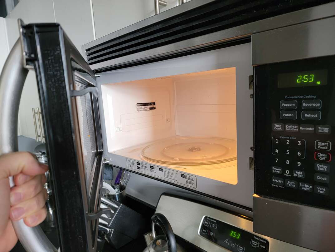 Open door of microwave reveals interior of appliance as well as the tag where you can find the serial number and model number.