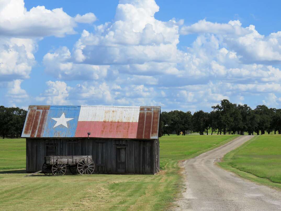 barn   buckboard wagon by rural road in Texas