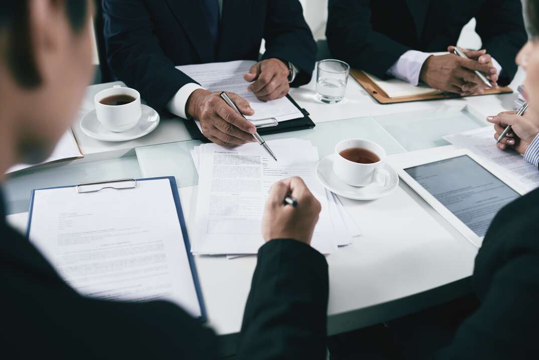 Hands of business people or lawyers analyzing documents on table