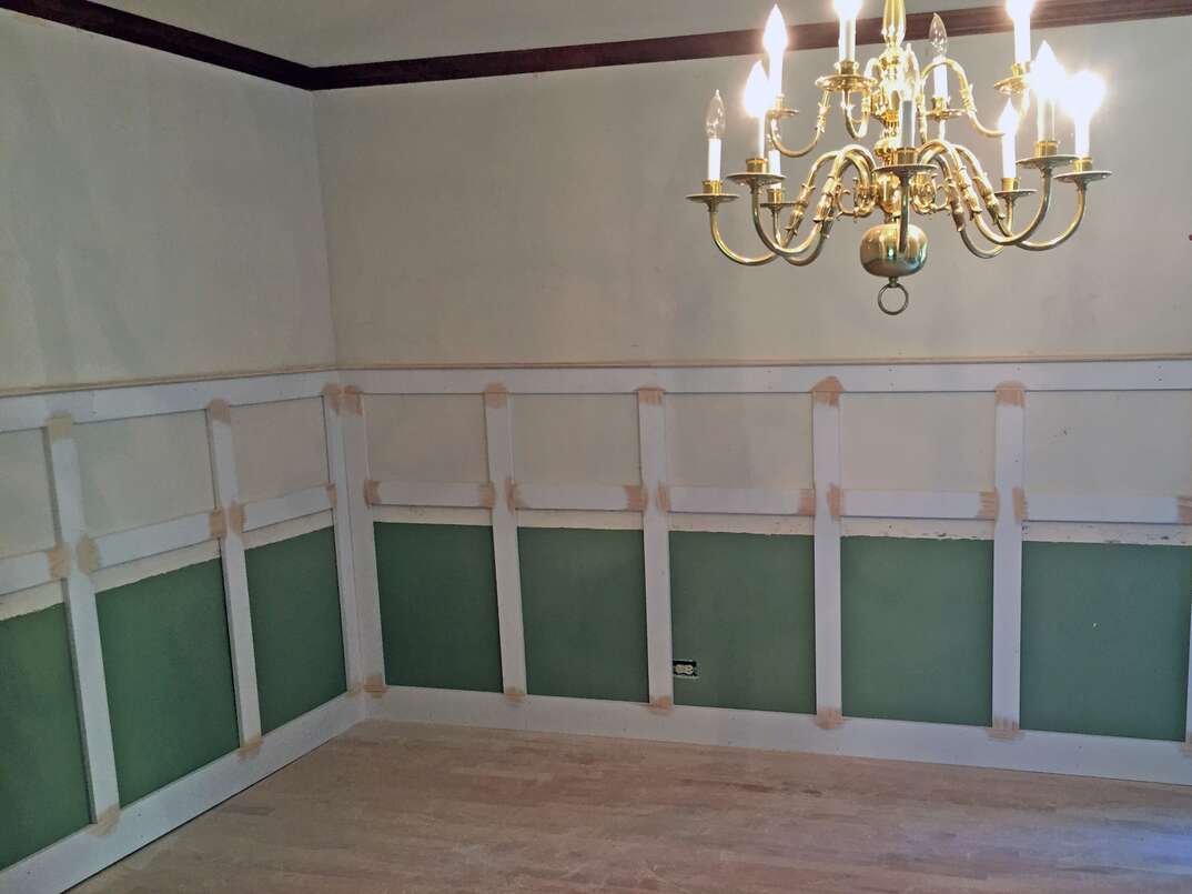 Wainscoting attached to a wall and being prepared for paint