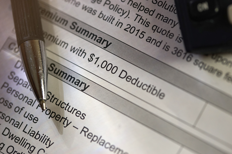 A closeup of an insurance form shows a one thousand dollar deductible as a pen as an ink pen points at the paper, insurance form, deductible, insurance deductible, property insurance, homeowners insurance, document, insurance document, pen, ink pen