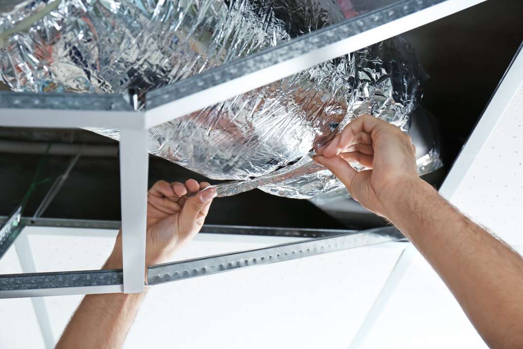 Male technician repairing industrial air conditioner indoors