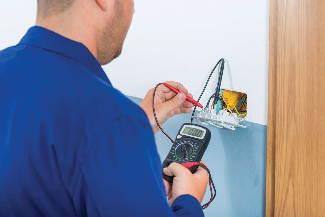 electrician fixing electrical outlet