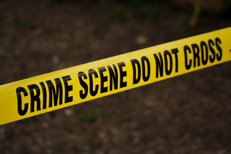 A strip of yellow police tape displays the order of Crime Scene Do Not Cross against a dark background, yellow police tape, police tape, tape, police, police line, line, crime scene investigation, crime scene, investigation