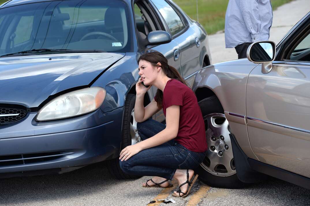 Young woman making phone call after accident