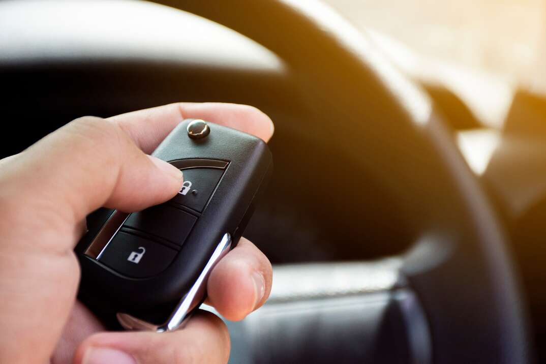 The driver's hand is pressed to the remote car keyless.