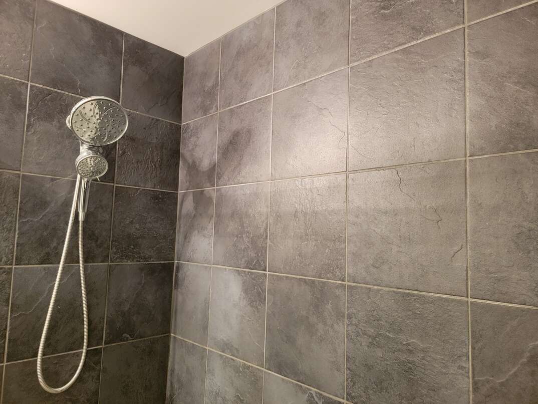 tiled shower with handheld showerhead