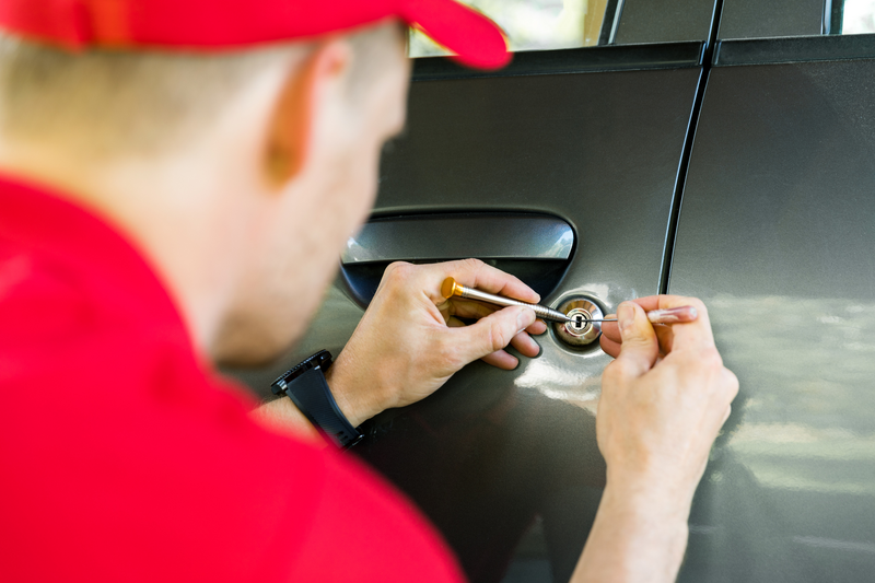 locksmith opening car door with lockpicker