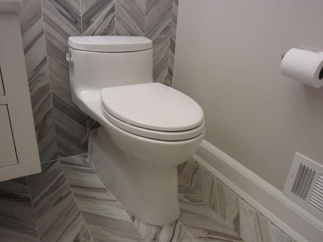 Bathroom toilet with tile floor and walls