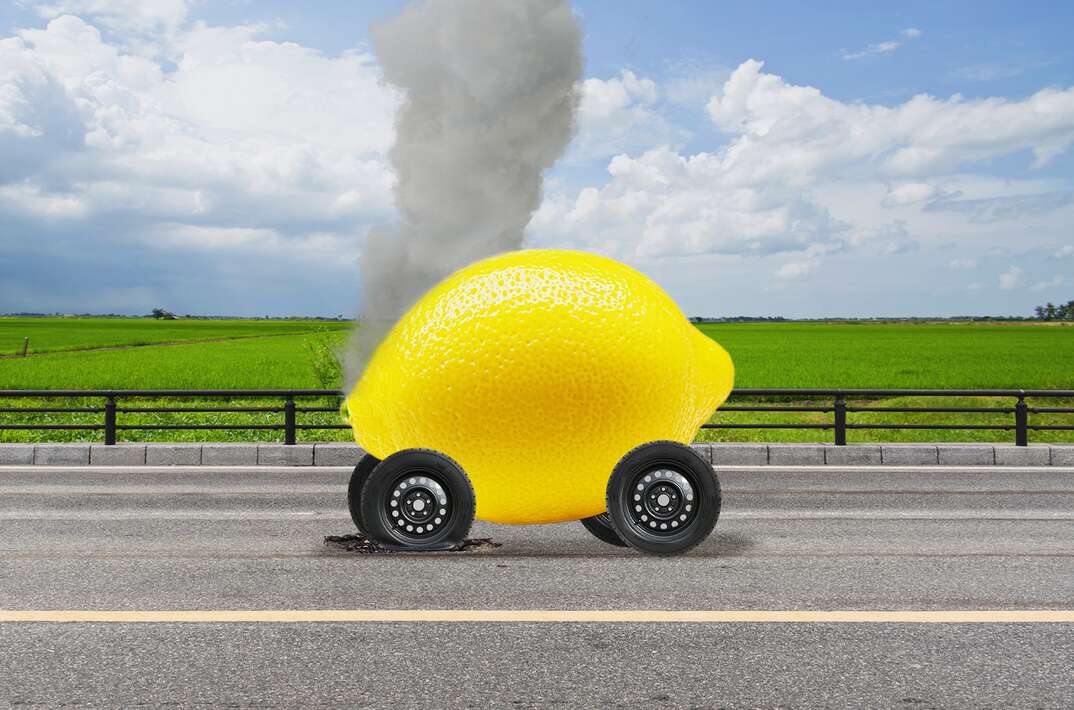 photo-realistic illustration of a lemon on wheels with smoke coming out of it