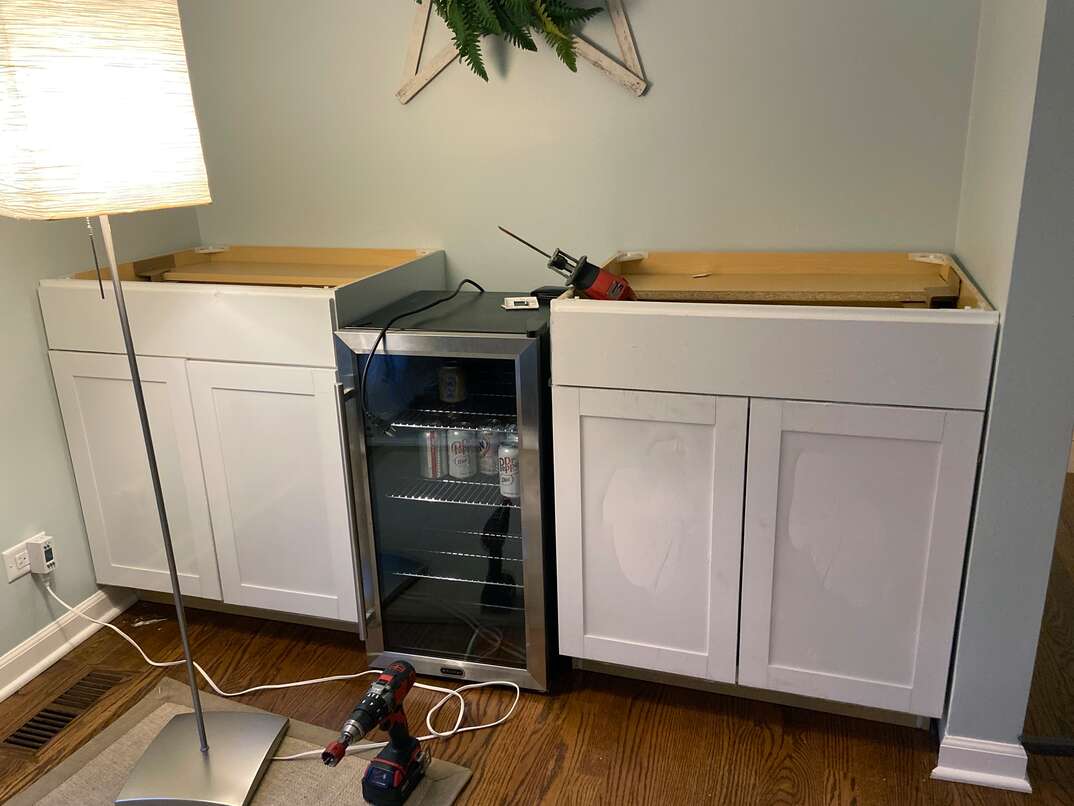 wide shot showing the new white shaker cabinets leveled and attached to the walls 