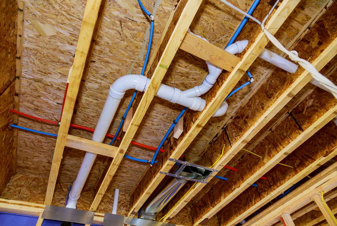 Home construction with hot red and cold blue pex pipe layout in pipes and exposed beams