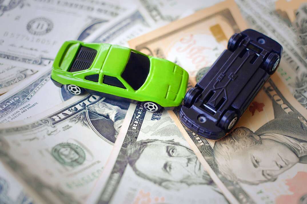 Toy cars in acciden on a background of 100 dollar bills