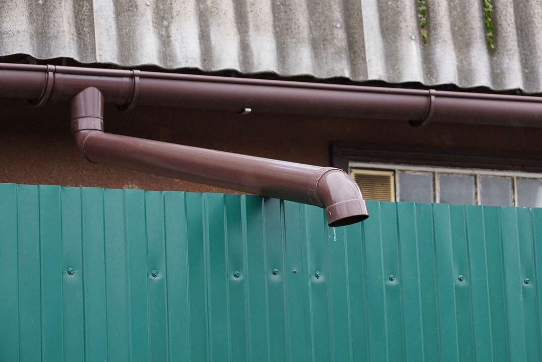 one long brown plastic gutter pipe