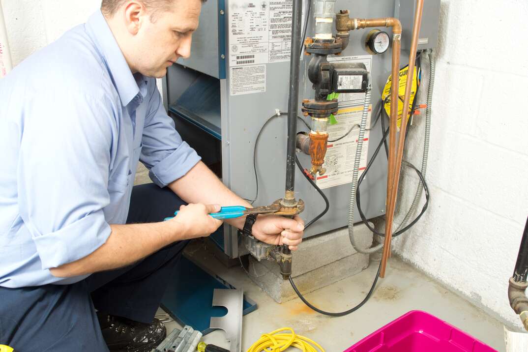 technician fixing furnace