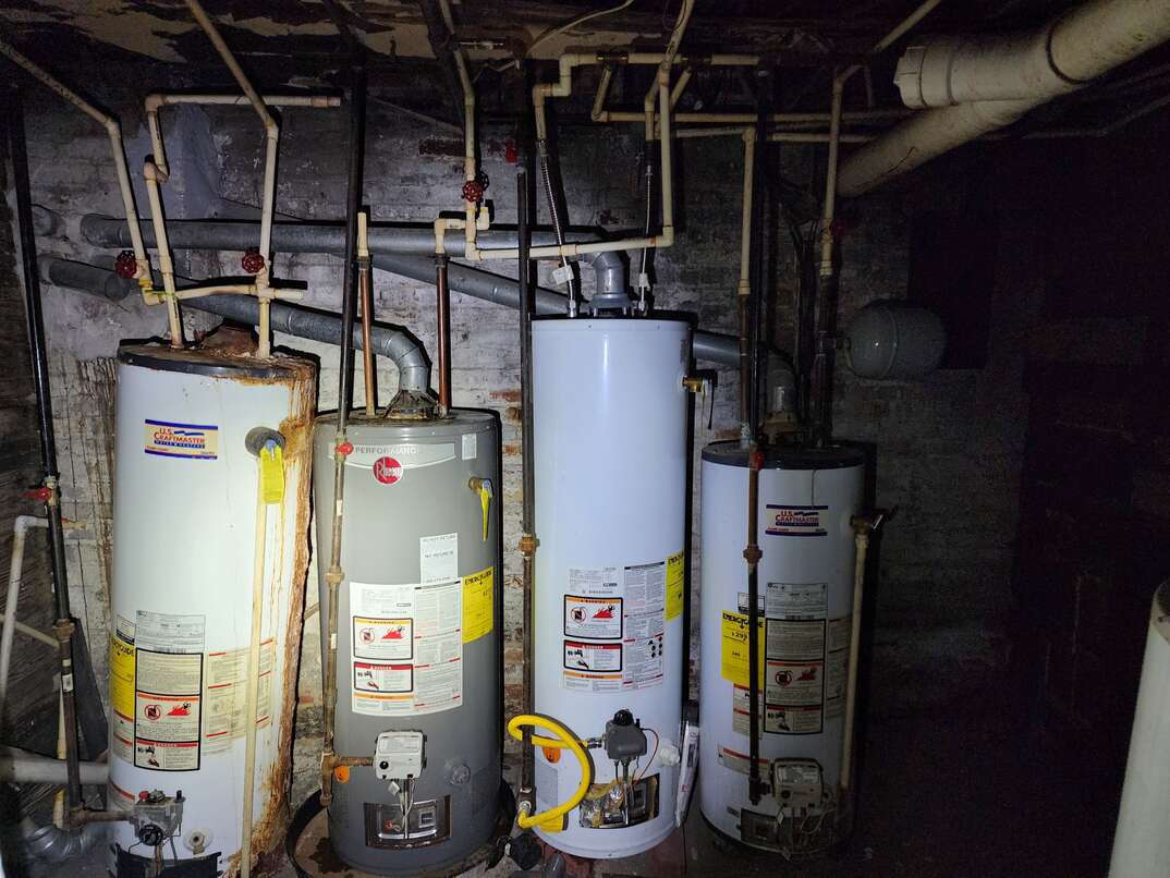 Rusty and damaged water heaters in customer basement