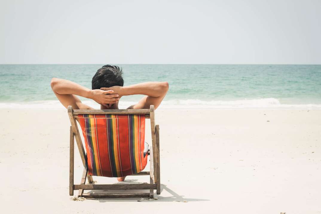 man enjoying sitting at the beach on vacation