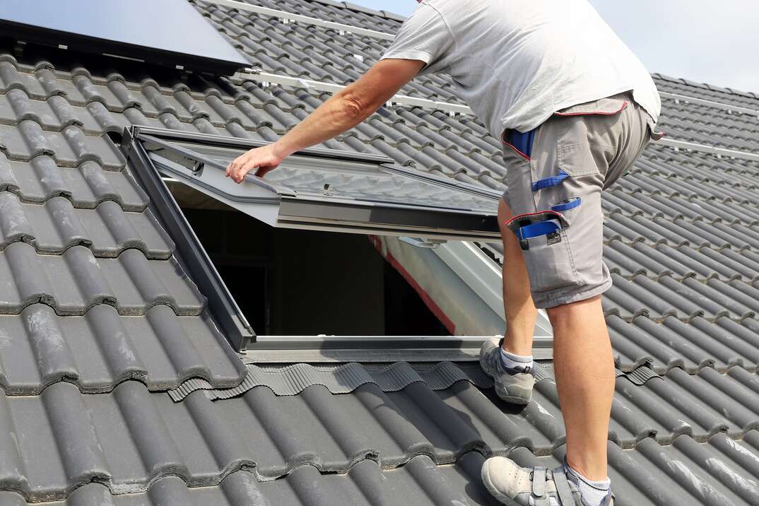 Professional installing a skylight on a slate roof.