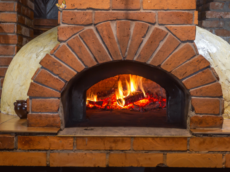 animation of a wood-fired brick pizza over with a flickering fire 