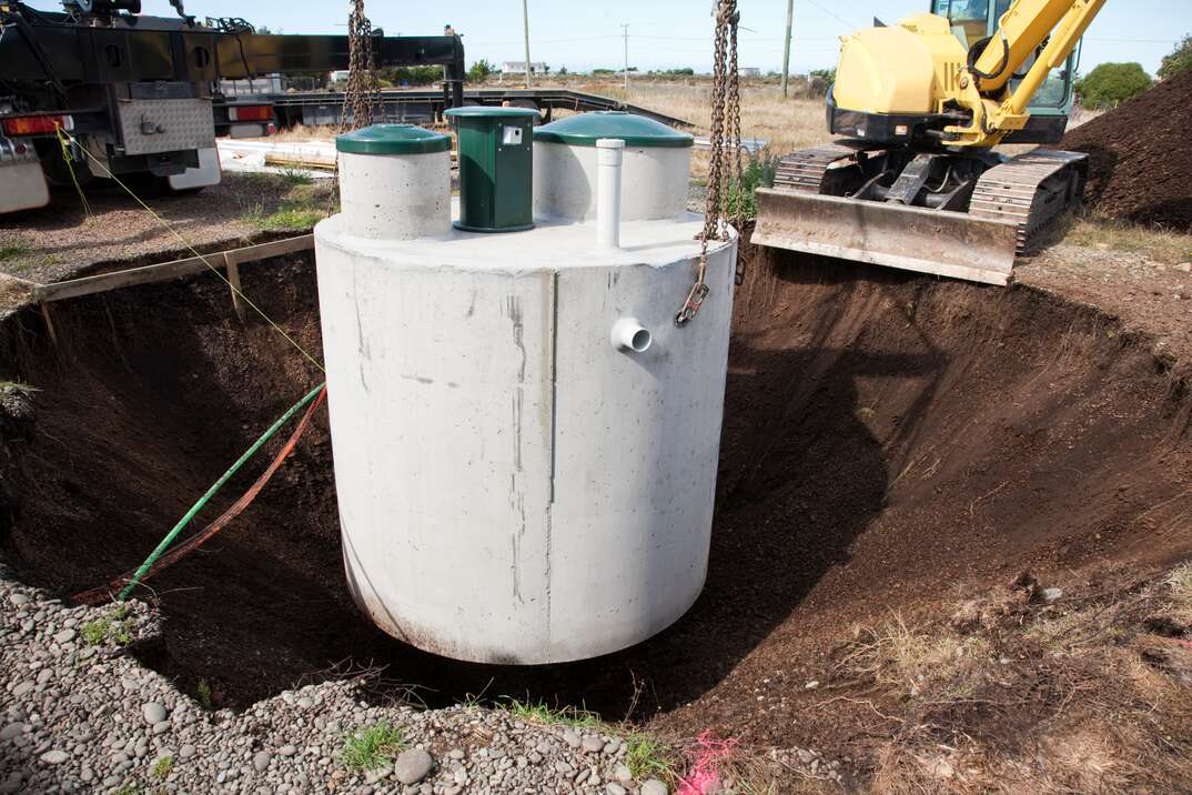Environmentally friendly septic tank being lowered into ground.  More building a home:-