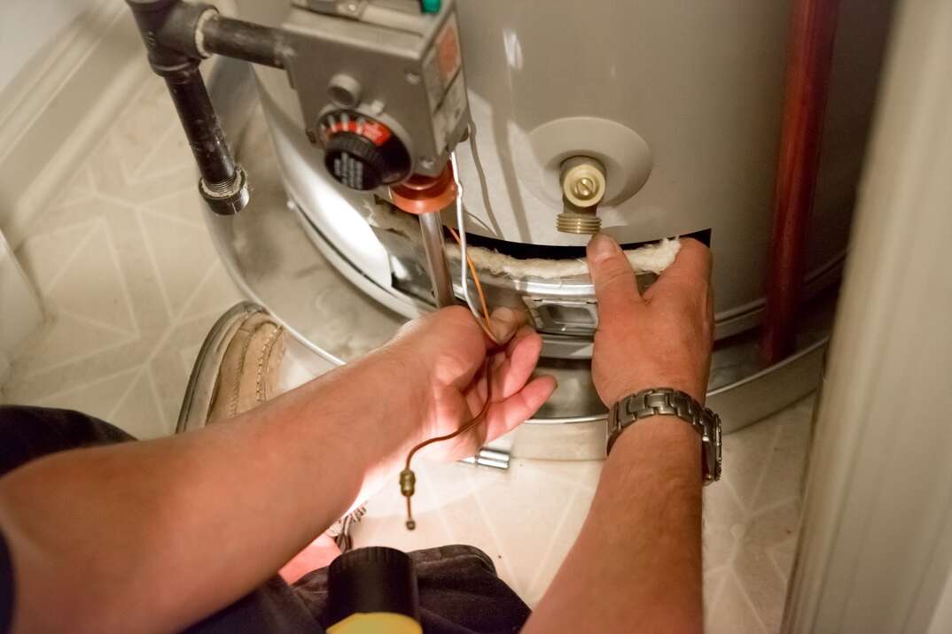 technician fixing water heater
