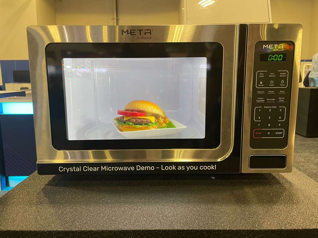 microwave with a clear screen cooks a burger
