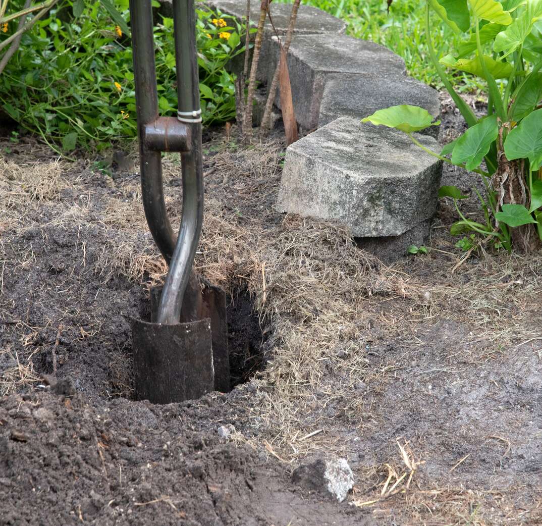 Post Hole Digger Prepares Ground for Fence Post