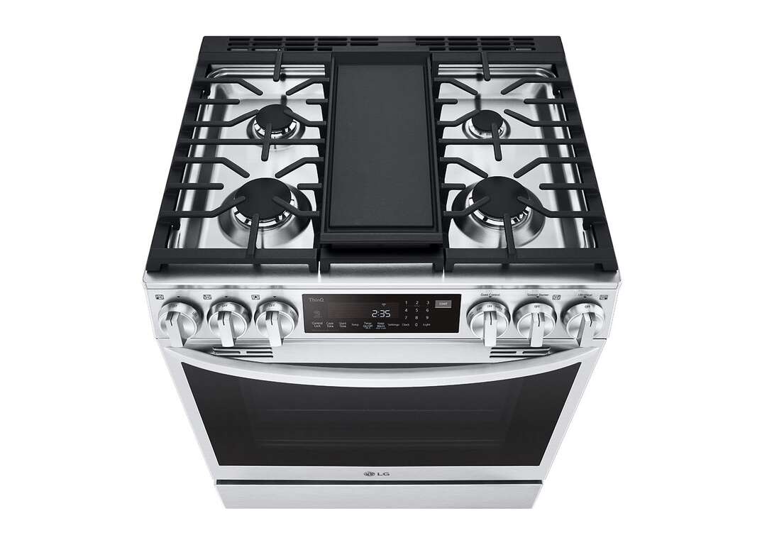 A stainless steel LG brand smart range with six knobs and a digital display panel and four gas burners covered by black grates and a black glass window in the oven door