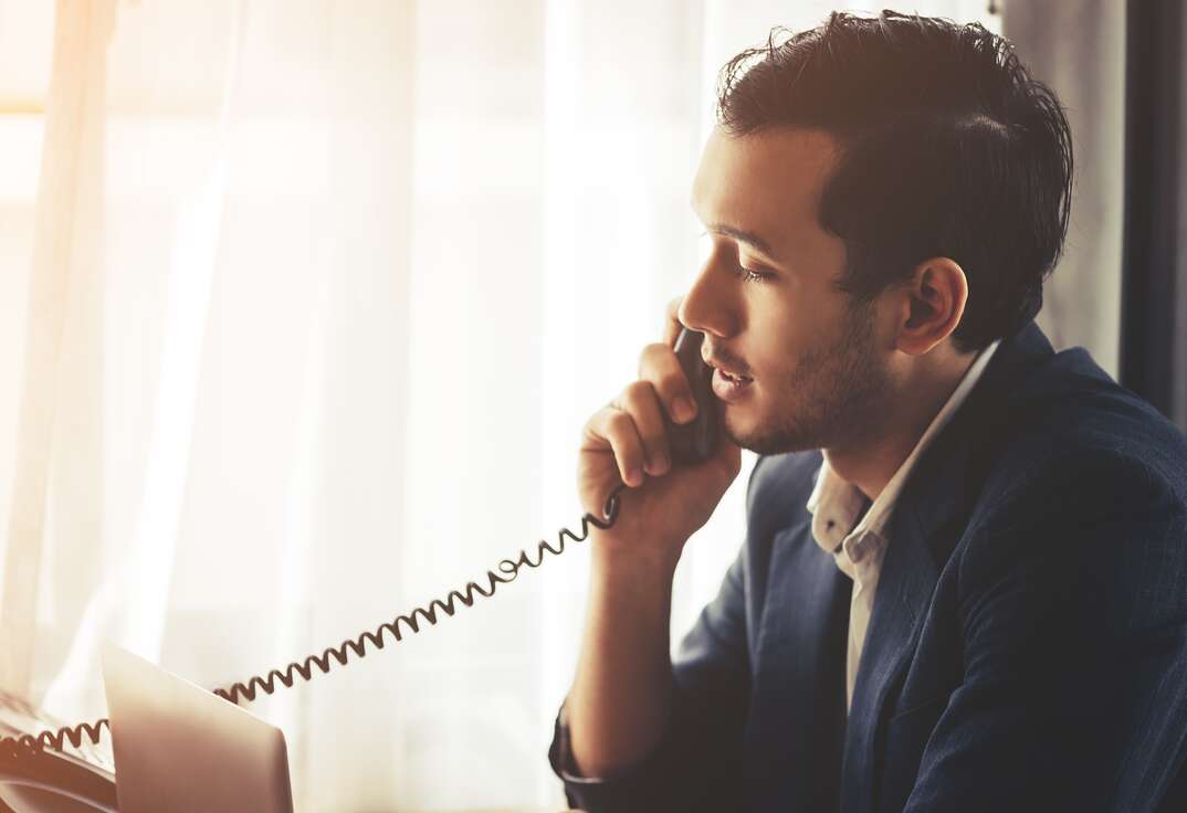 Business man is making call in on Fax phone landline