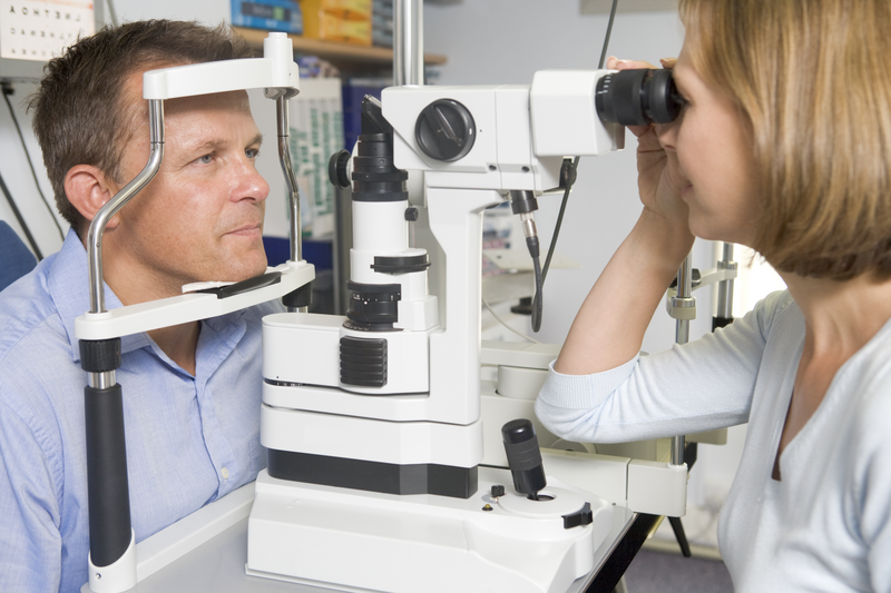 Woman having eyes tested by male optician