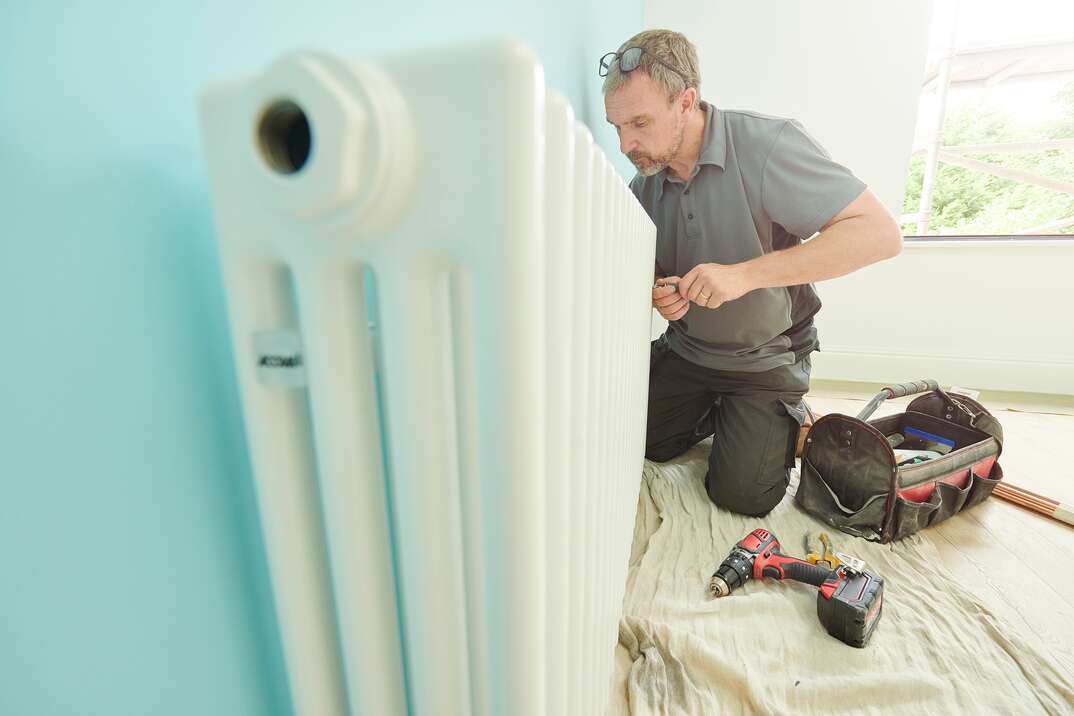 male plumber working on a residental radiator