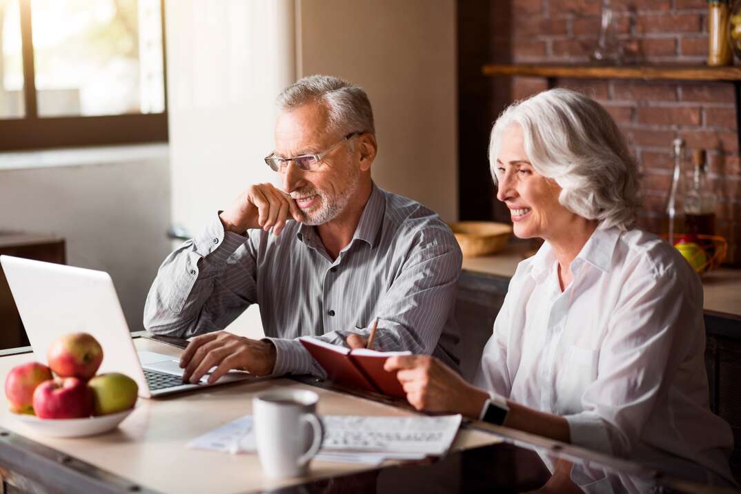 Joyful work together. Man in glasses typing while his attractive wife taking notes