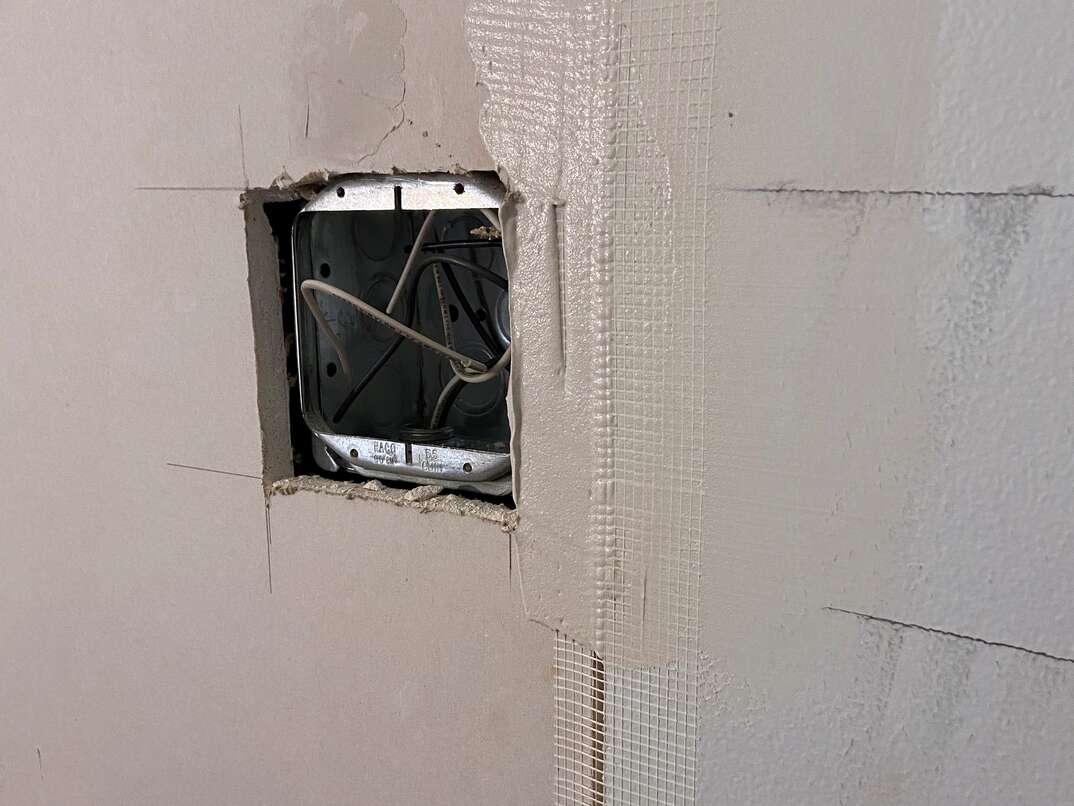 close up of drywall mud spread on to a taped seam of drywall.