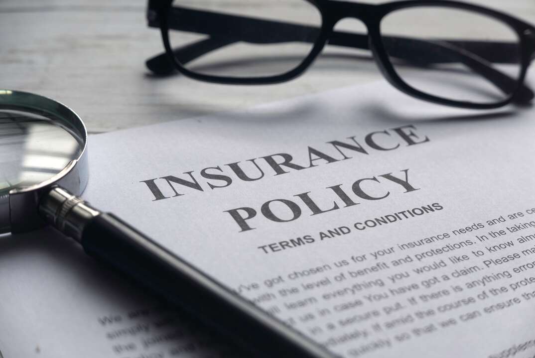 insurance policy on a desk with glasses