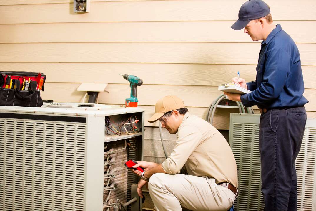 technicians checking external HVAC unit