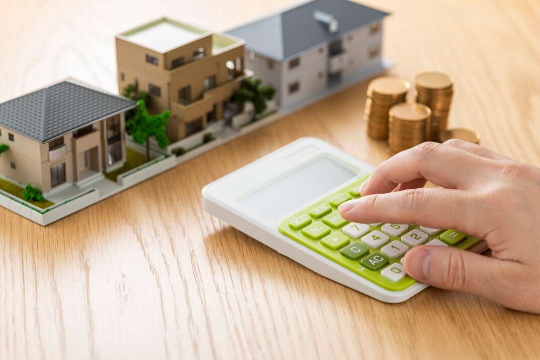 Man and house model calculating with calculator