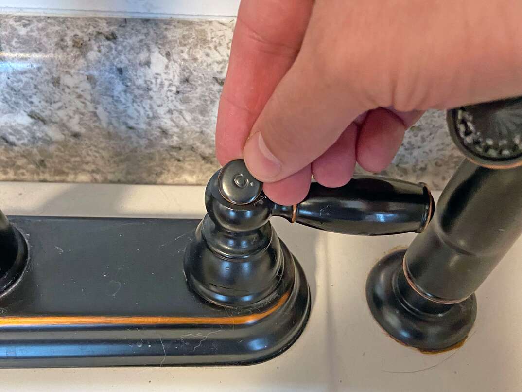step-by-step instructional guide on how to tighten the temperature handles on a sink In this case, we are looking at an oil rubbed faucet on a utility sink