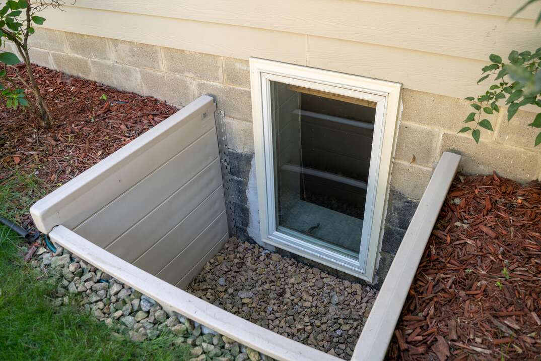 Exterior view of an egress window in a basement bedroom  These windows are required as part of the USA fire code for basement bedrooms