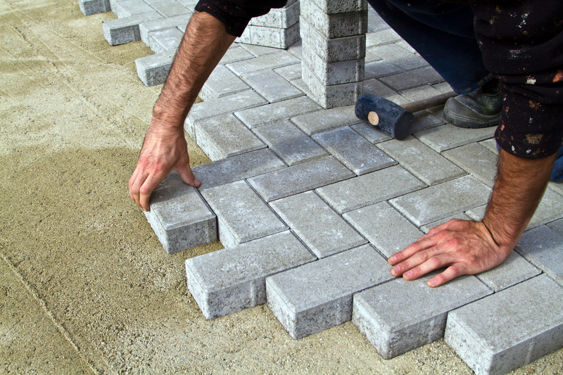 Construction of pavement. Worker puts paving