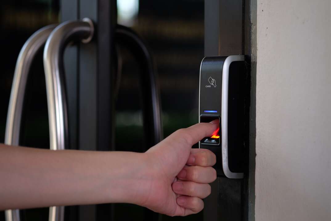 person putting their thumb on a fingerprint lock