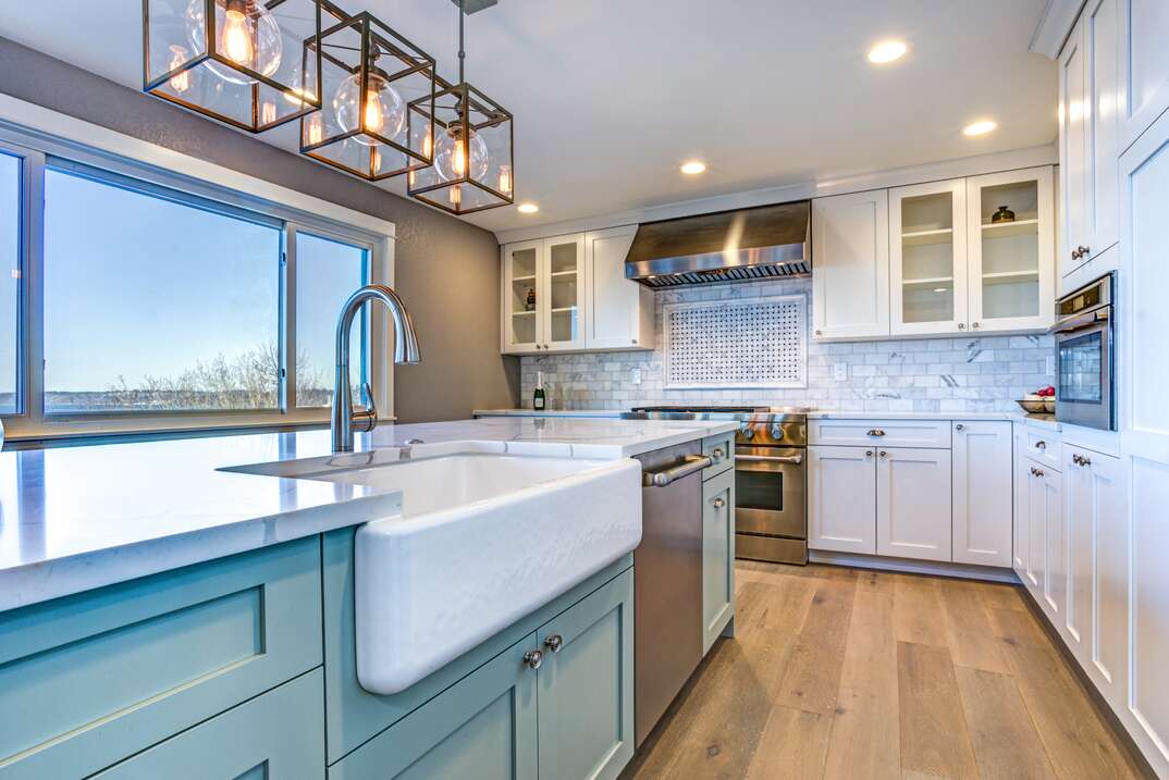 Beautiful kitchen room with green island and farm sink 