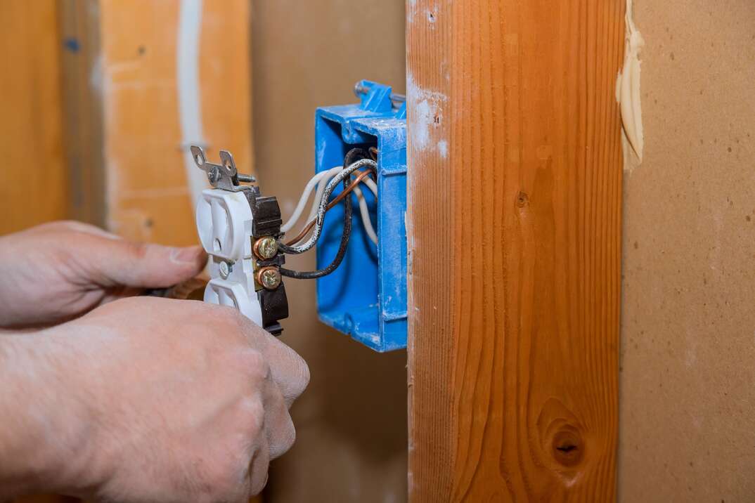 Preparing to remove an electrical outlet of the screws for electrical wires