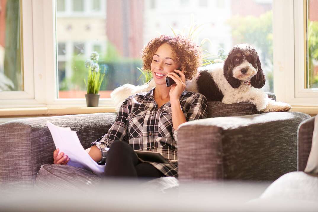 woman on phone looking at a piece of paper